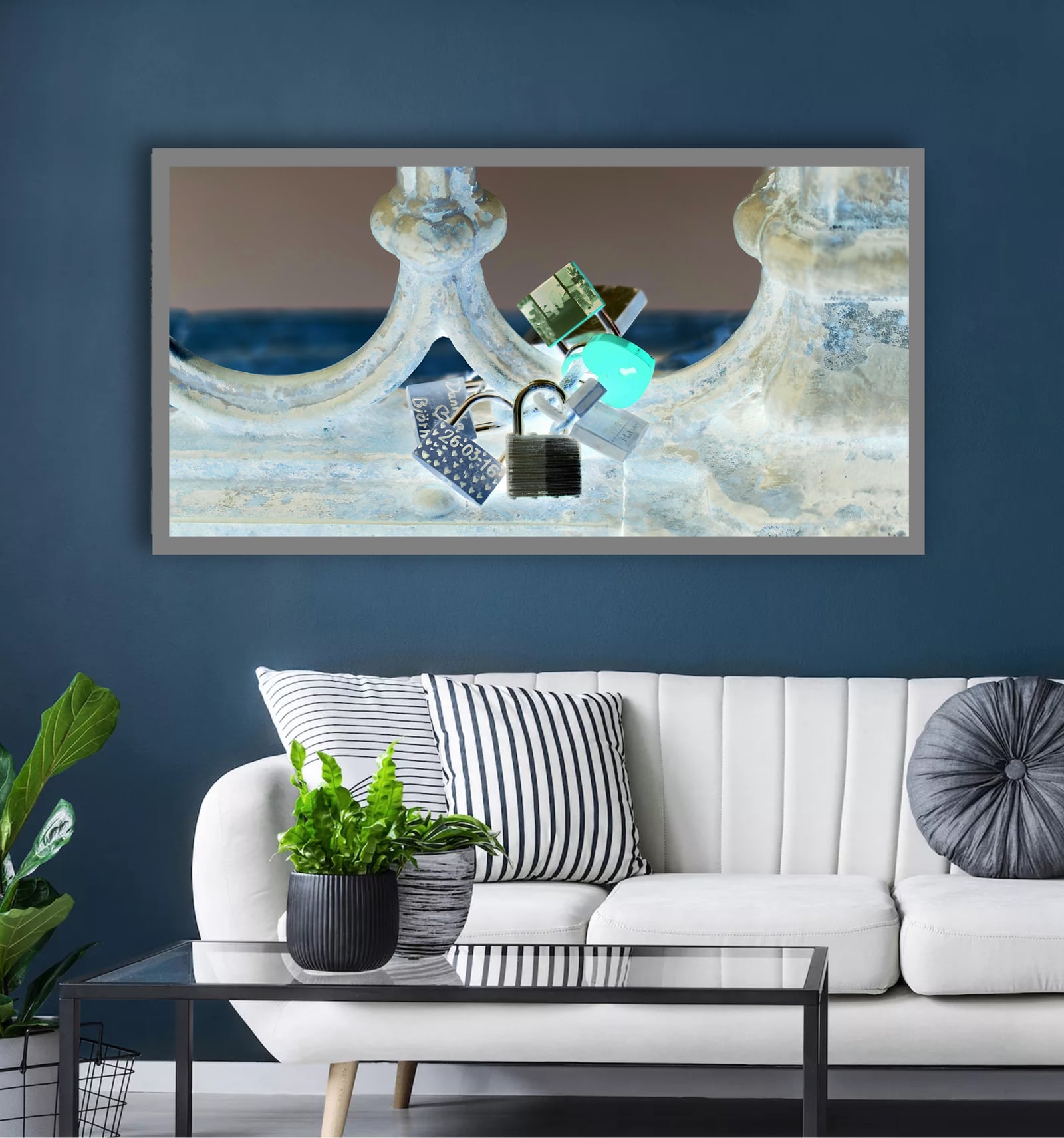 A wide framed coastal photograph above a white sofa against a navy wall