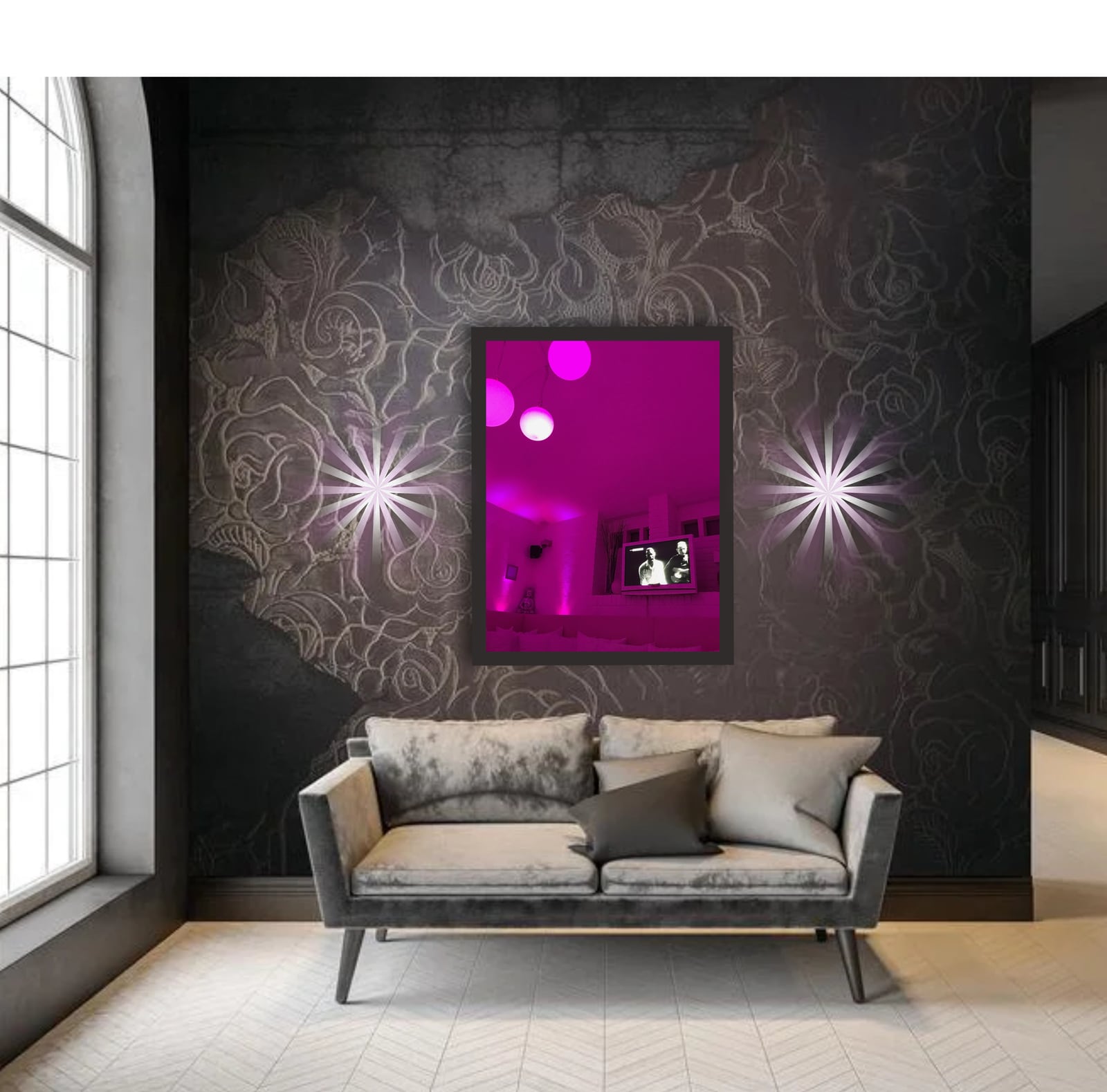 A framed magenta photograph between wall lights above a sofa on a dark textured wall
