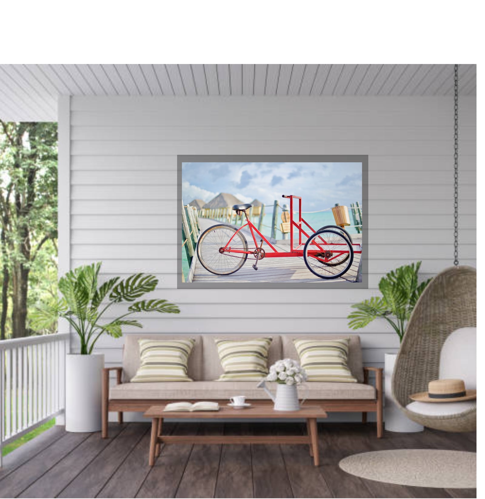 A framed red bicycle photograph above a sofa on a white-panelled porch